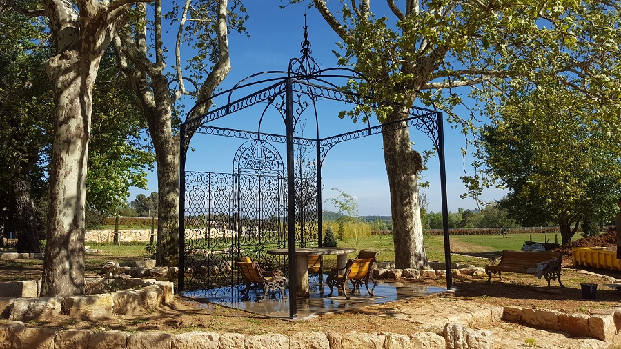 pergola romatique en fer forgé dans un beau jardin